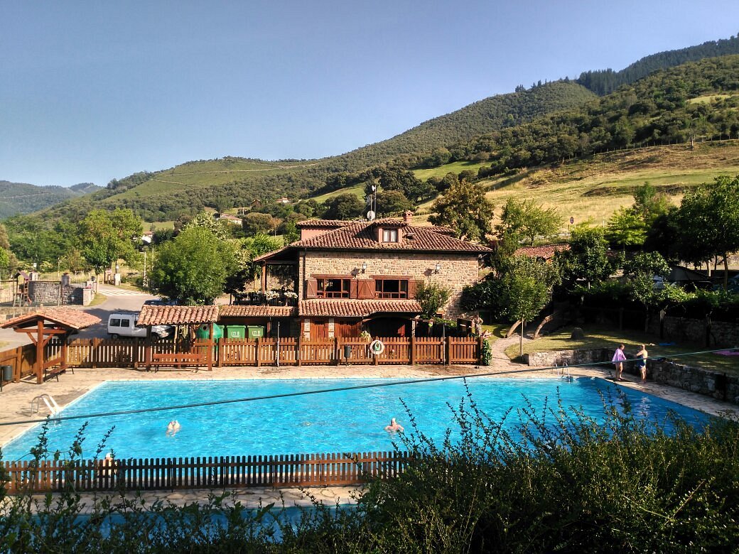 Piscina del Camping la Viorna con las montañas al fondo