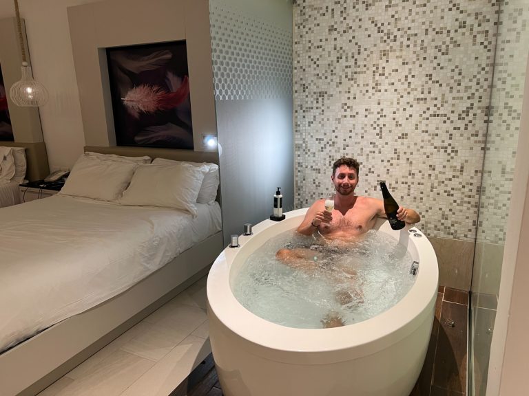 Jacuzzi junto a la cama en una habitación del Royalton CHIC Punta Cana