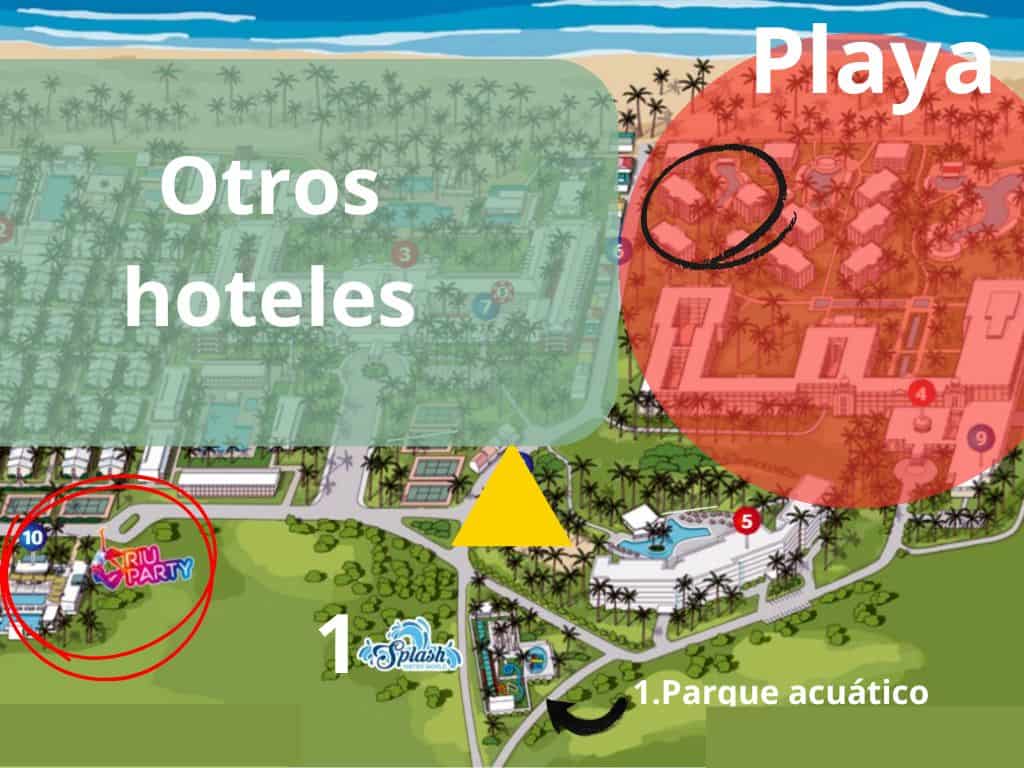 Colorful water park with slides and pools for families and kids under palm trees.