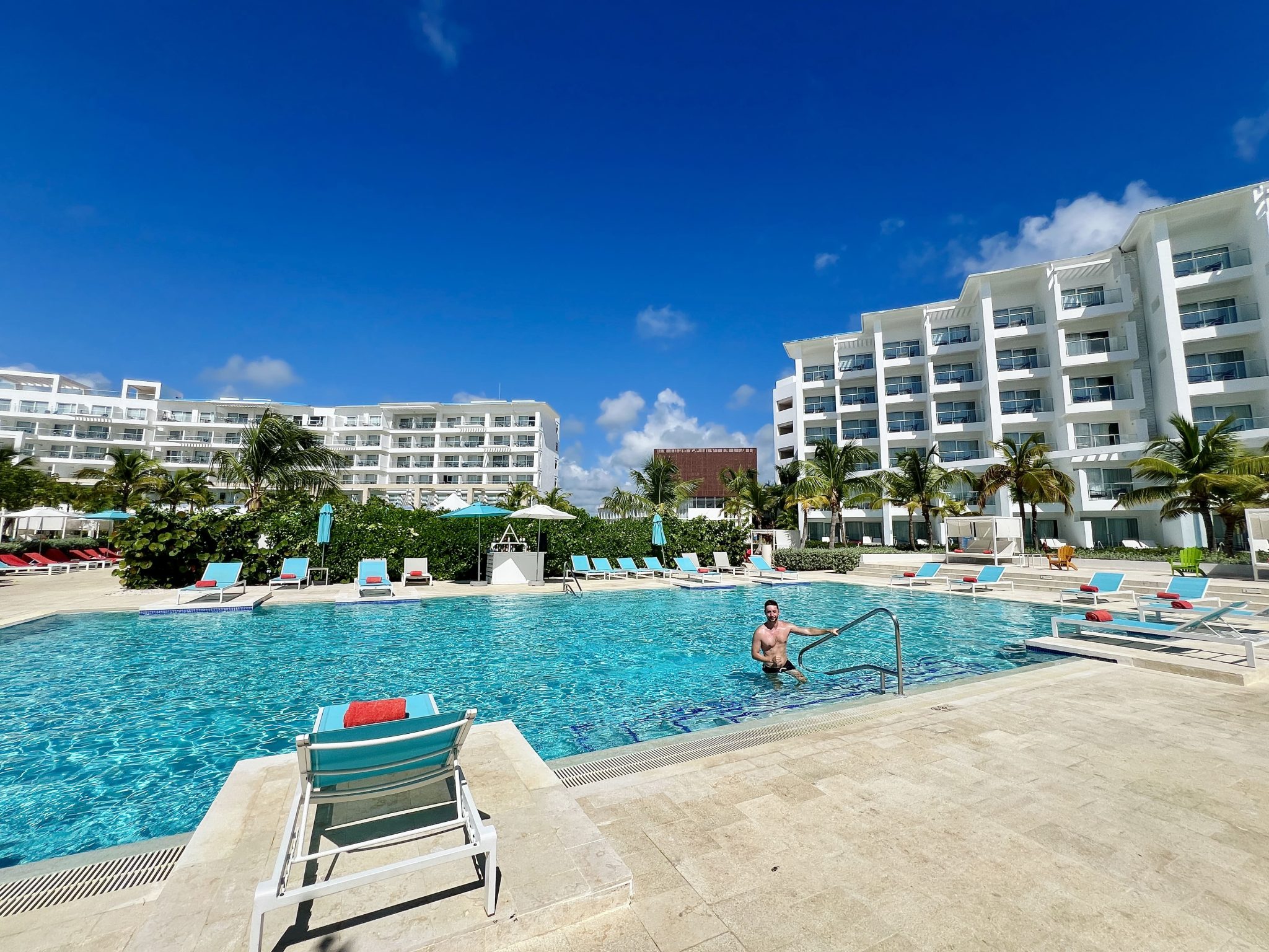 Piscina del Dreams Cap Cana con el edificio de habitaciones al fondo