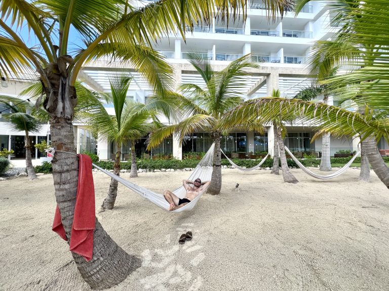 Hamacas a la sombra de los árboles sobre arena, dentro del recinto del Dreams Cap Cana