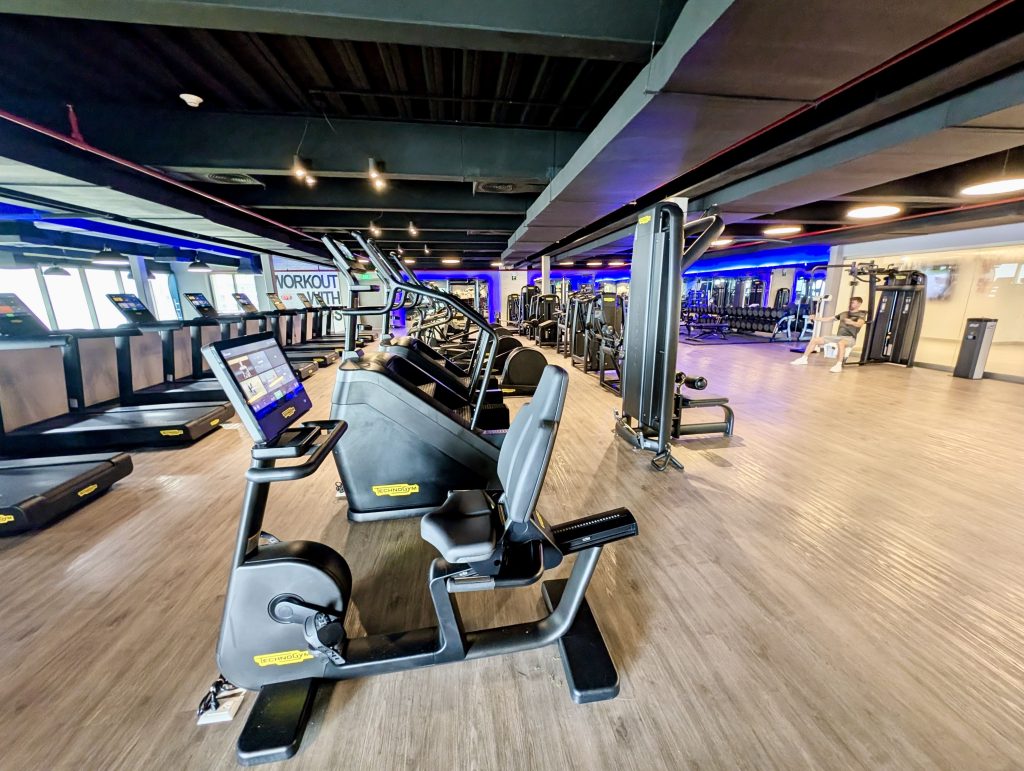 Gimnasio del Dreams Riviera Cancún con máquinas de cardio y vistas al jardín