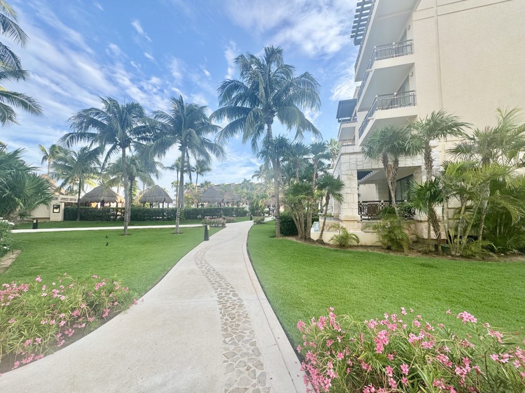 Zona de paseo ajardinada entre los edificios del Dreams Riviera Cancún