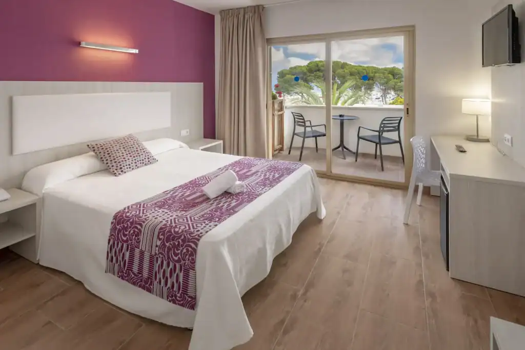 Cozy hotel room with balcony, sea view, and modern furnishings in Mediterranean style.