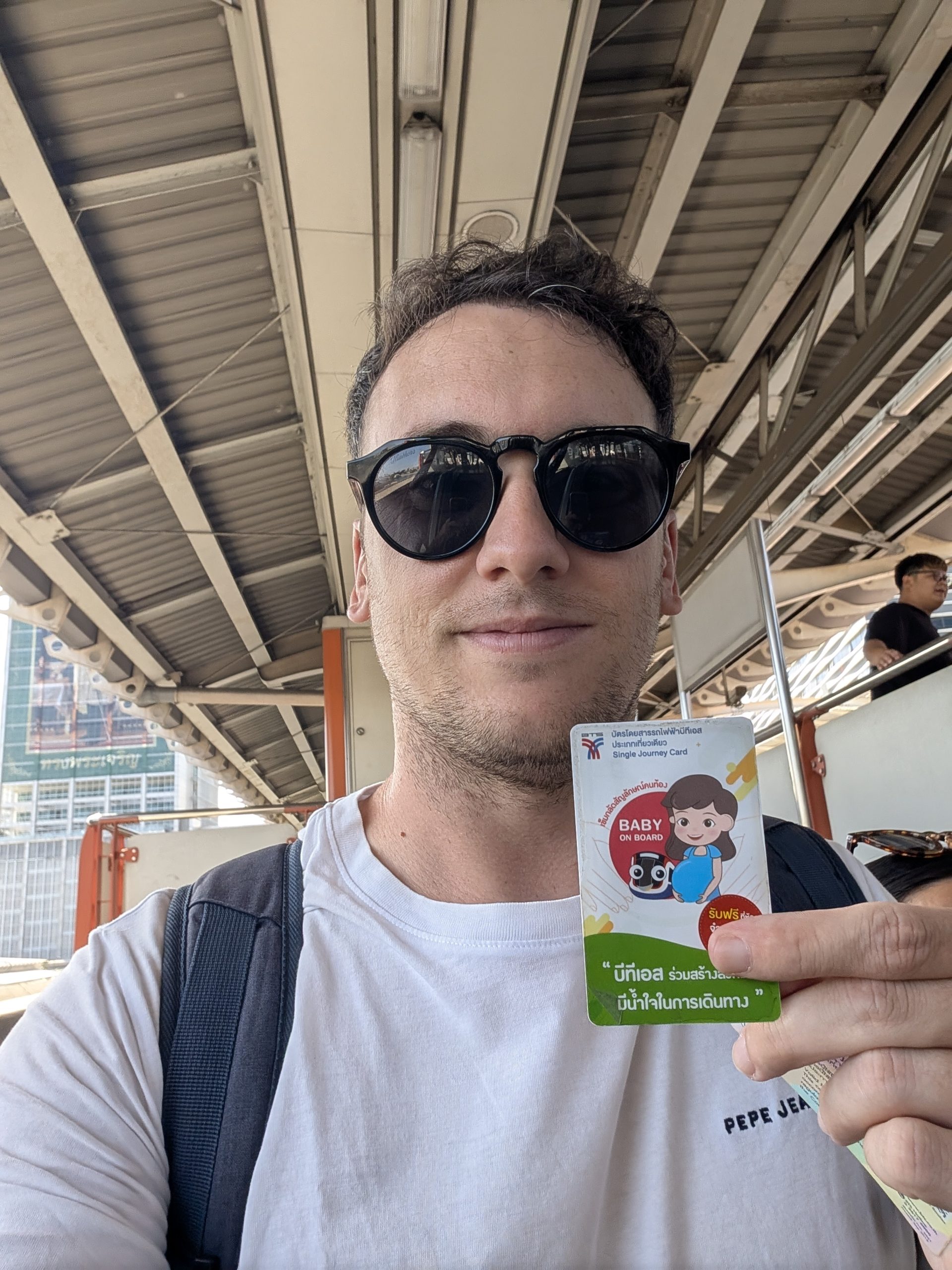 Víctor con una Single Journey Card del BTS en la mano, en una estación de Bangkok