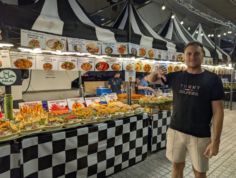 Puesto de marisco para turistas en Bangkok, con los platos fotografiados en carteles y los precios en baht