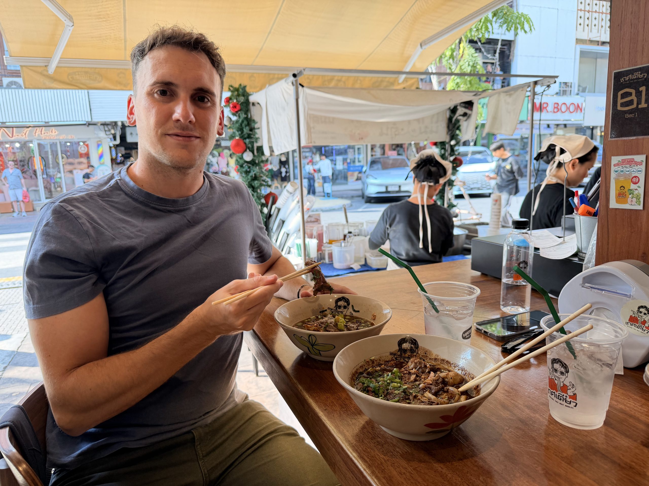 Dos cuencos de fideos con ternera y caldo oscuro en la barra de Siam Noodles, un local abierto a la calle en Bangkok