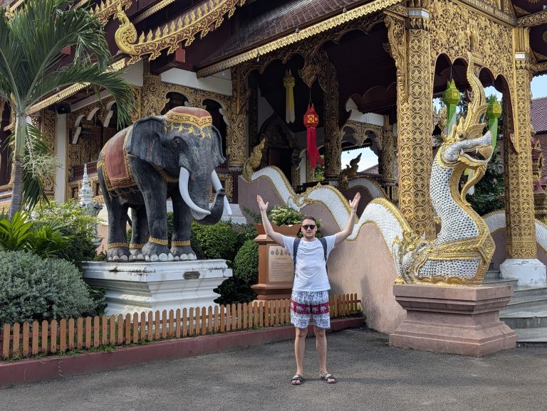 Entrada de un templo de Chiang Mai, con un elefante de piedra a un lado y una serpiente naga al otro