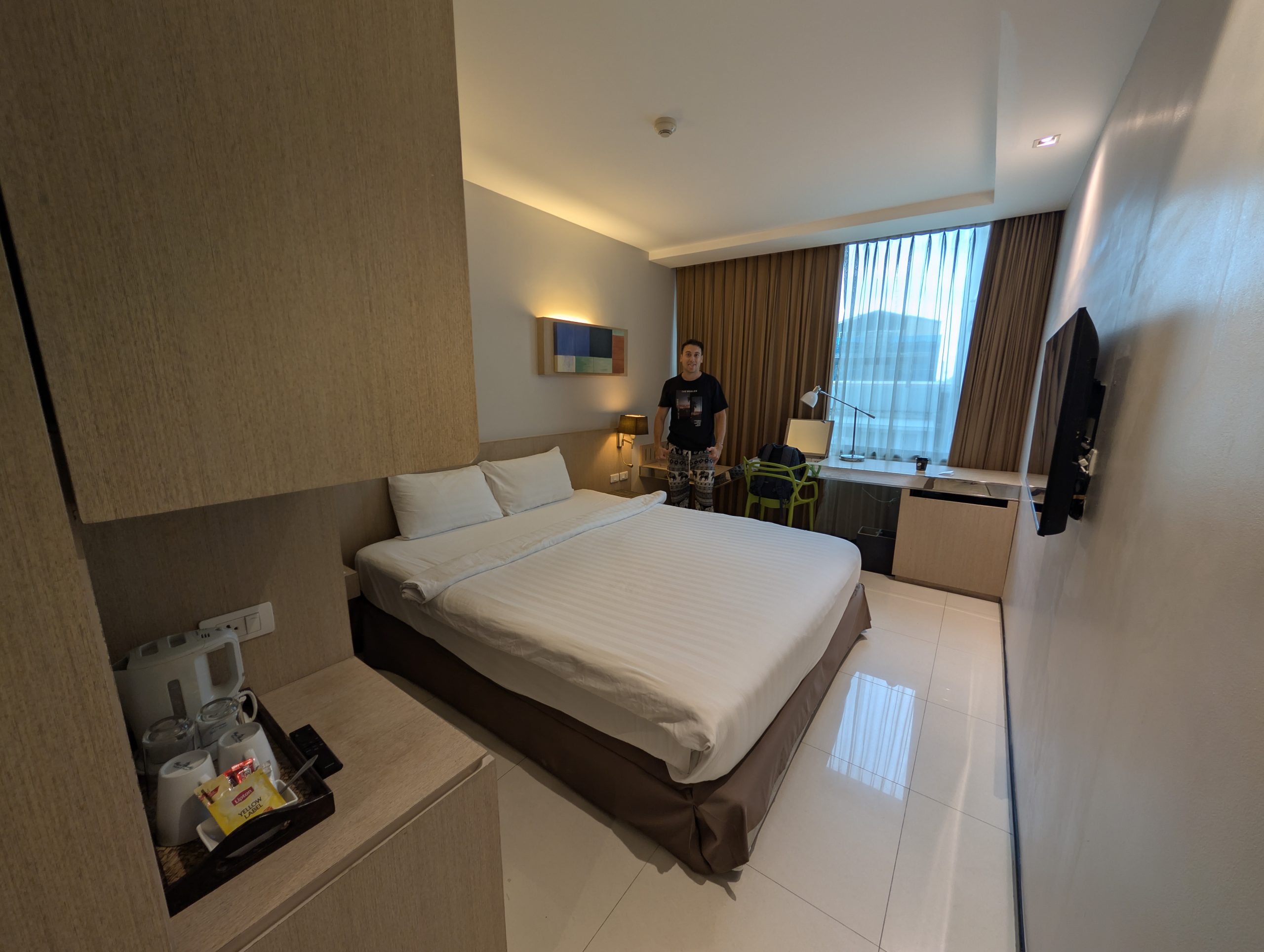 Habitación del VIC 3 Bangkok Hotel, con cama grande, escritorio y bandeja de té