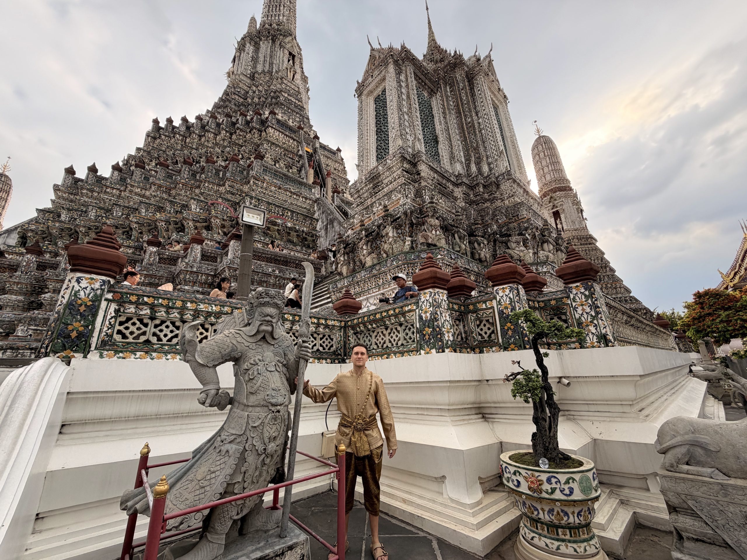 Víctor con el traje tradicional tailandés alquilado delante del templo Wat Arun, junto a uno de sus guardianes de piedra