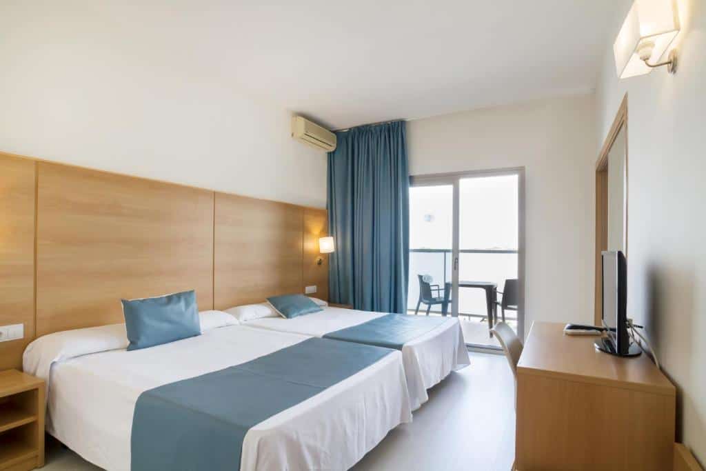 A comfortable hotel room with two beds, a balcony, and modern decor.