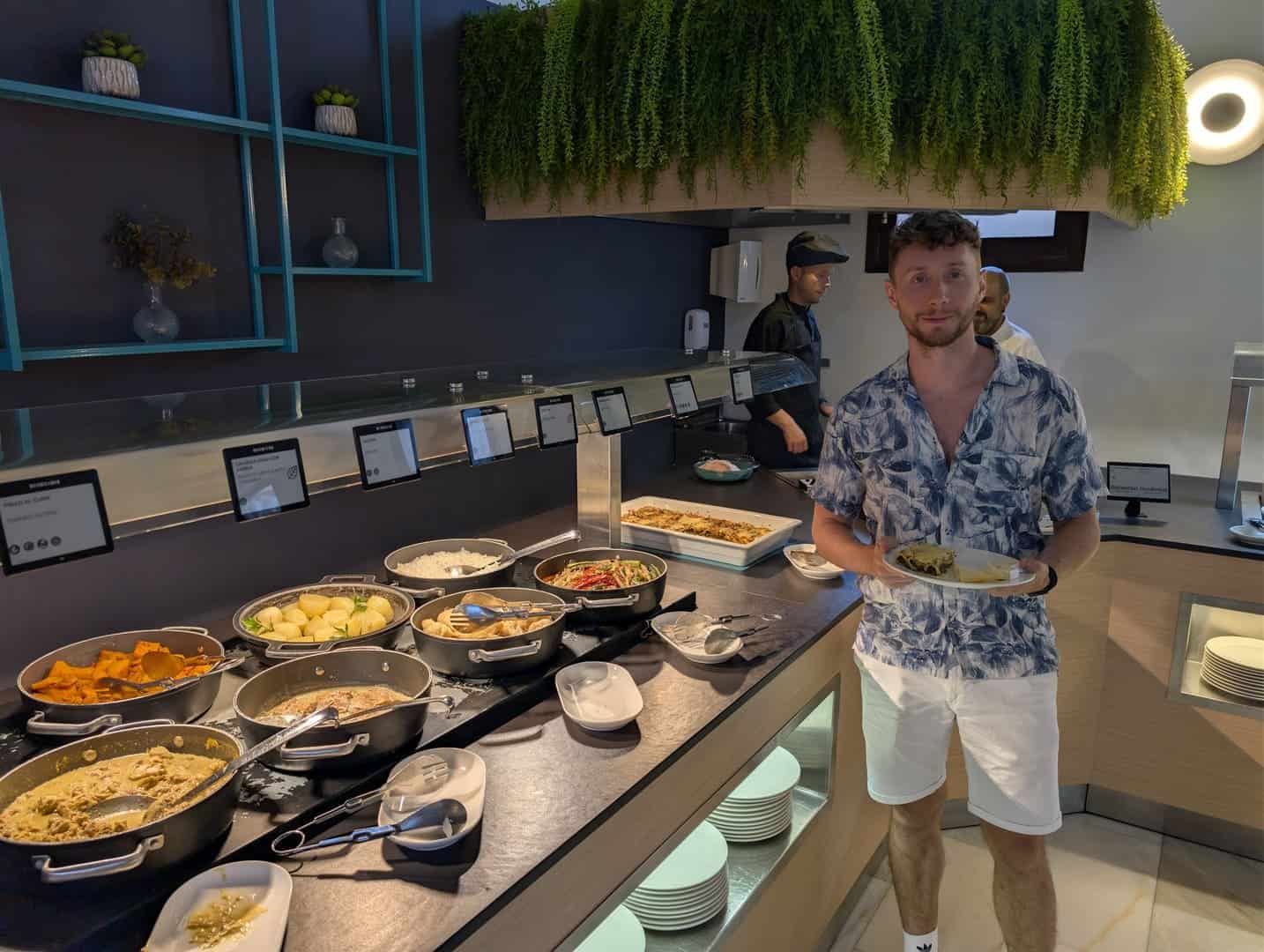 Javier Sobrino sirviéndose en el buffet de la cena del Occidental Pueblo Acantilado, con la cocina en vivo detrás