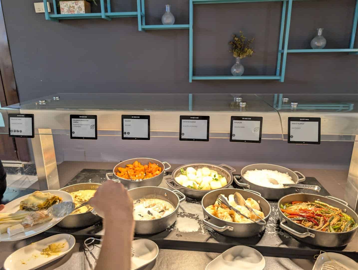 Bandejas de platos calientes y verduras en el buffet de la cena del Occidental Pueblo Acantilado