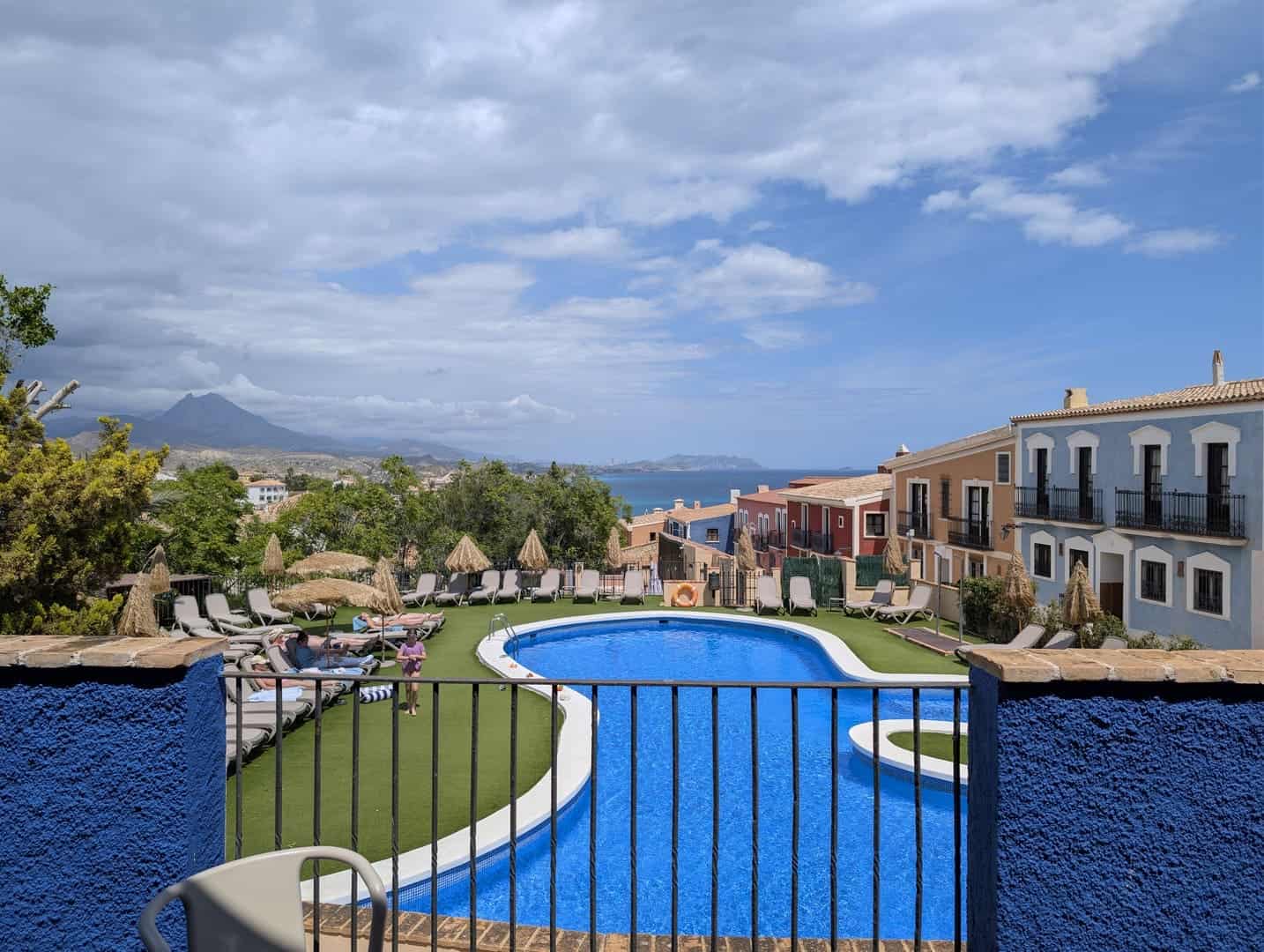 La piscina del Occidental Pueblo Acantilado, con las casas de colores, la sierra y el mar al fondo