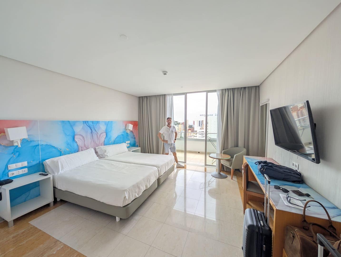 Cama de la habitación del BCL Levante Club con televisión y salida a la terraza
