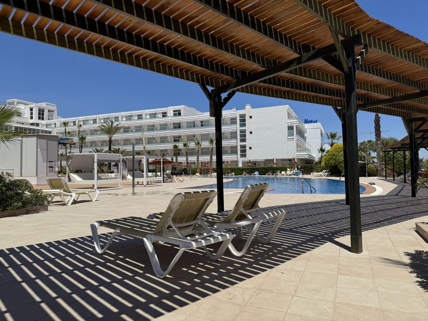 Zona de tumbonas con sombra junto a la piscina del Servigroup Marina Playa