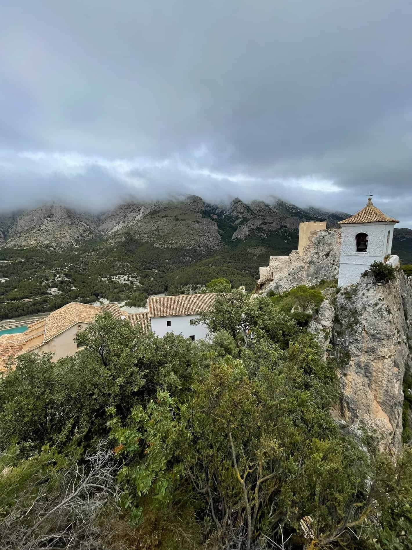 Campanario de Guadalest sobre la roca con el embalse turquesa