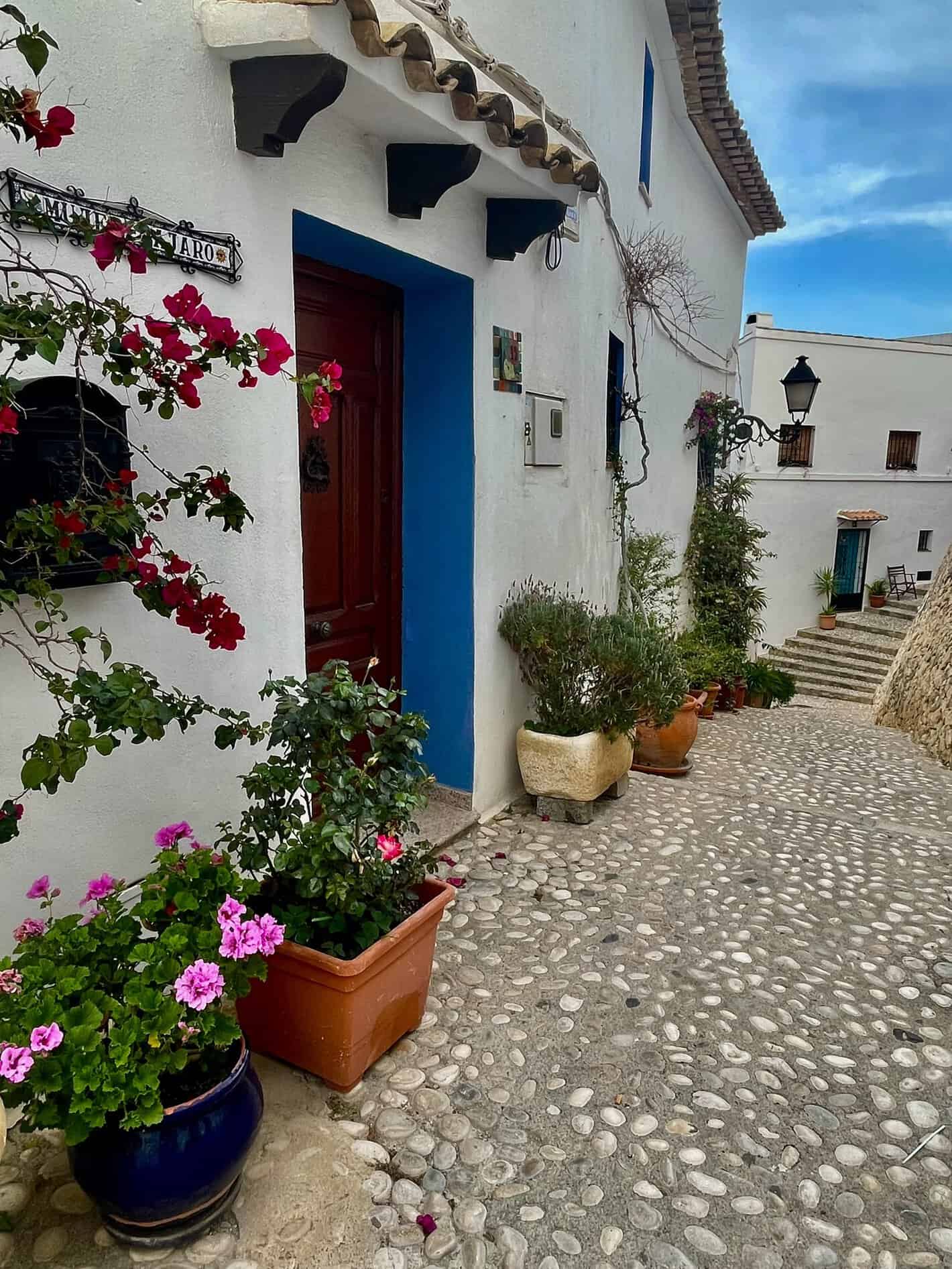 Casa blanca con puerta azul y flores en Altea