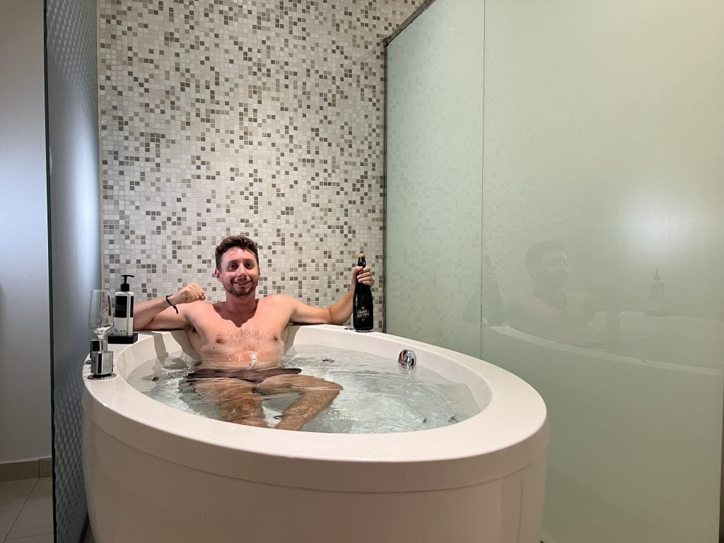 Jacuzzi junto a la cama en una habitación del Royalton CHIC Punta Cana