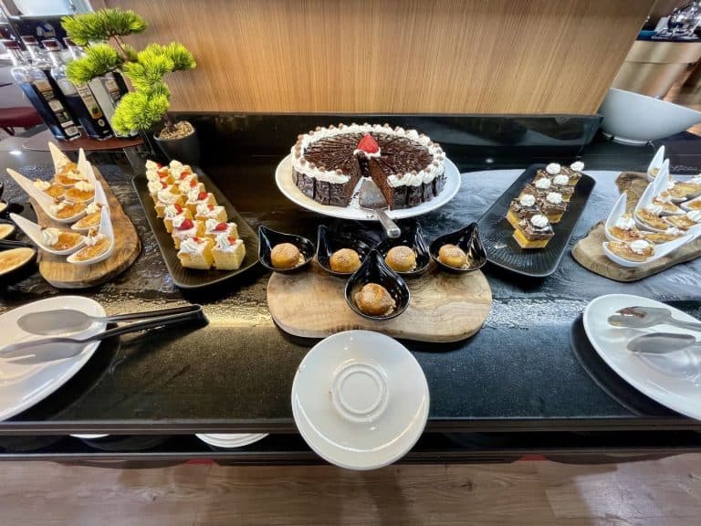 Mostrador de postres del buffet del Magic Fantasy con tarta de chocolate y brochetas de fruta