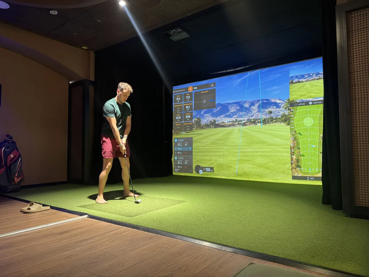 Sala del simulador de golf del Magic Sports, con la pantalla y el césped artificial