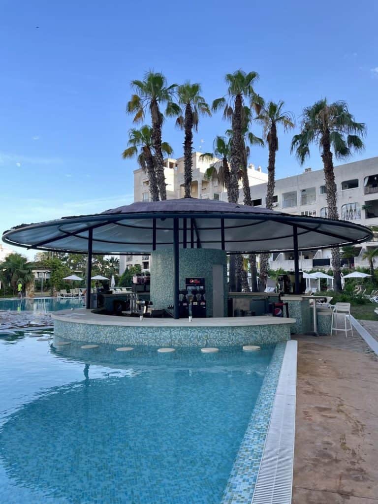 Chiringuito de la zona de césped junto a la piscina de Magic Splash, con palmeras