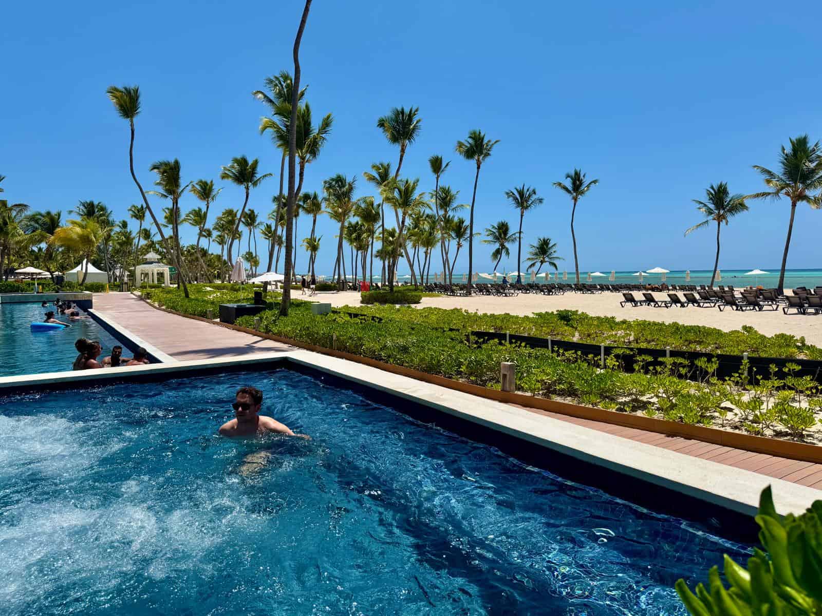 Jacuzzi de agua caliente del Hyatt Zilara Cap Cana con la playa detrás