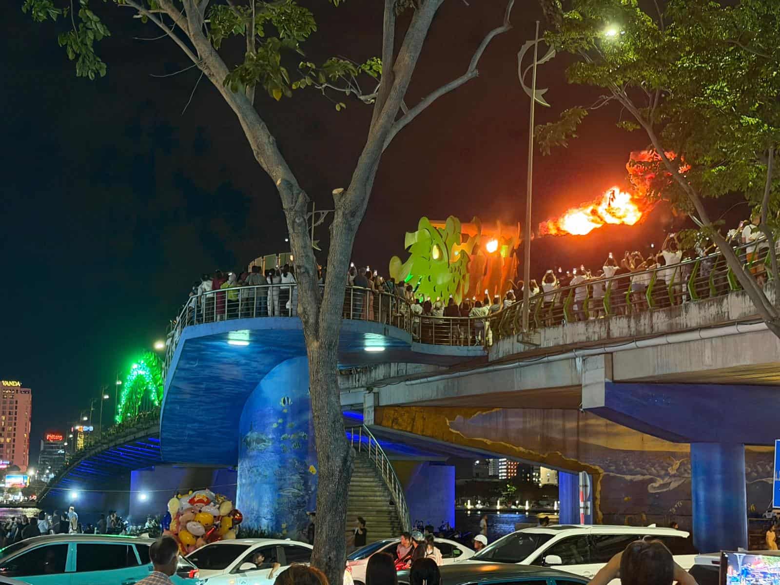 El puente del Dragón de Da Nang escupiendo fuego, con la pasarela llena de gente grabando