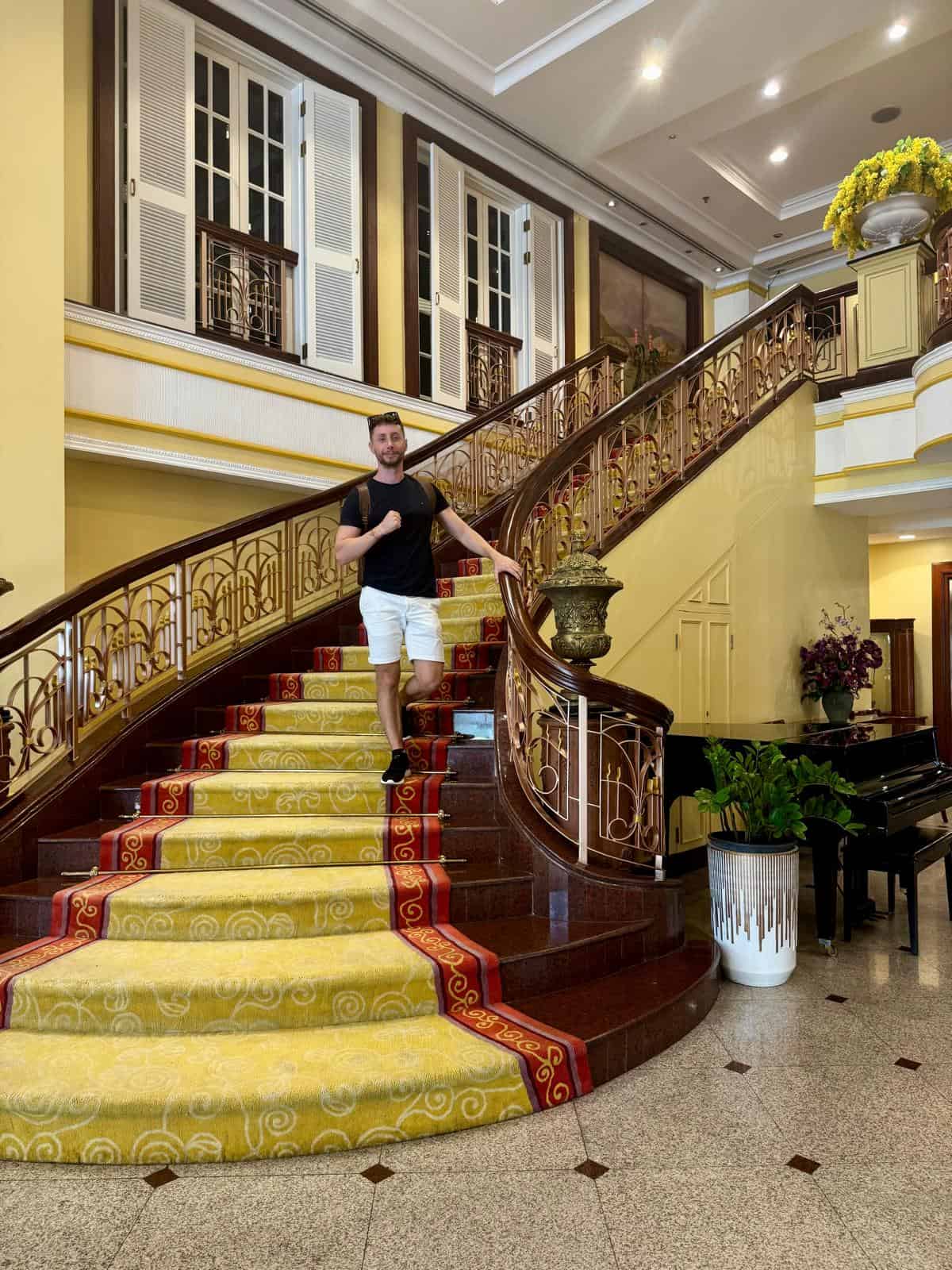 Escalera de la entrada del Evergreen Laurel Hotel, con alfombra amarilla y piano de cola