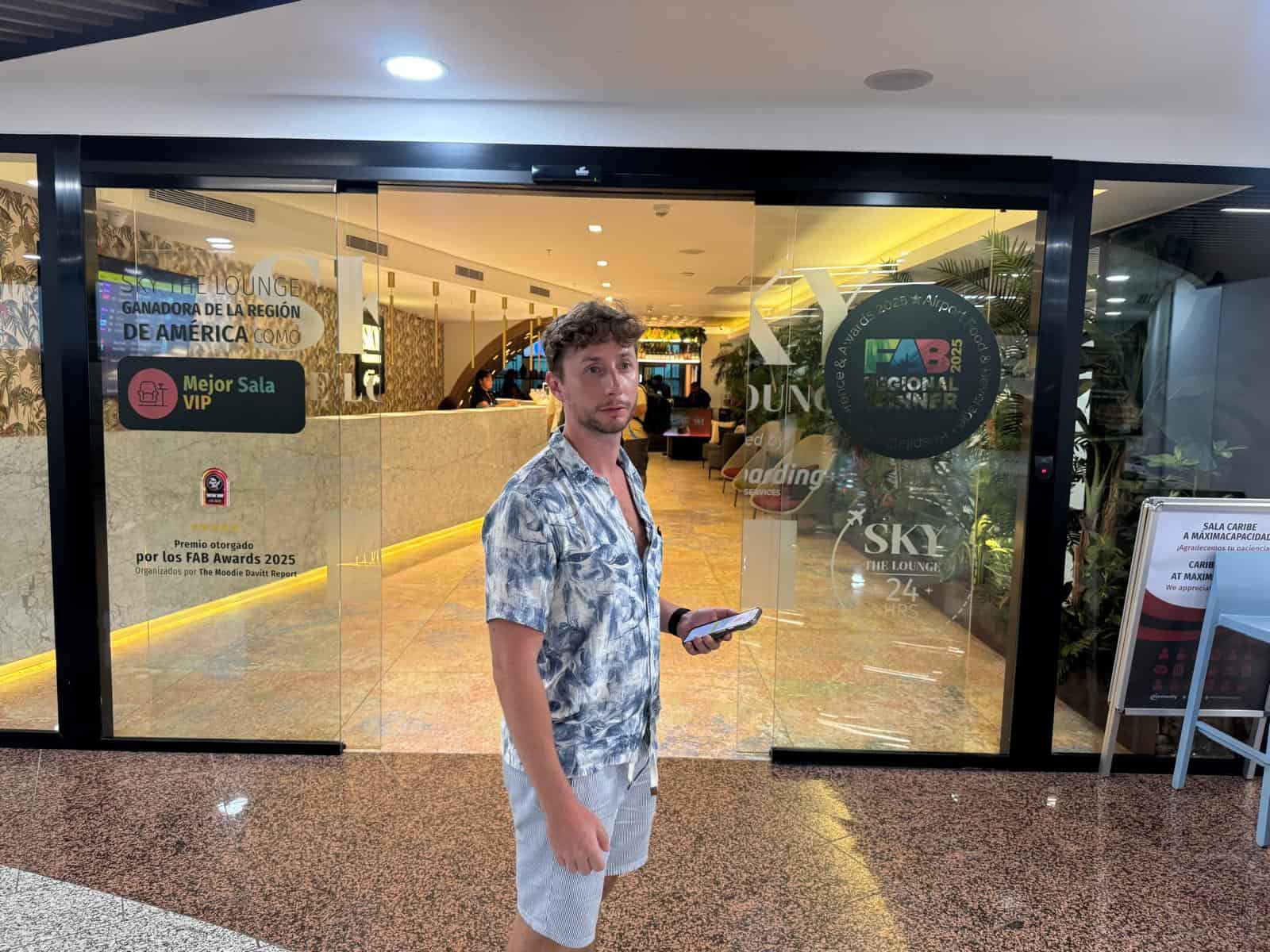 Entrada de la sala VIP Sky The Lounge del aeropuerto de Santo Domingo, con los carteles de mejor sala VIP de América 2025
