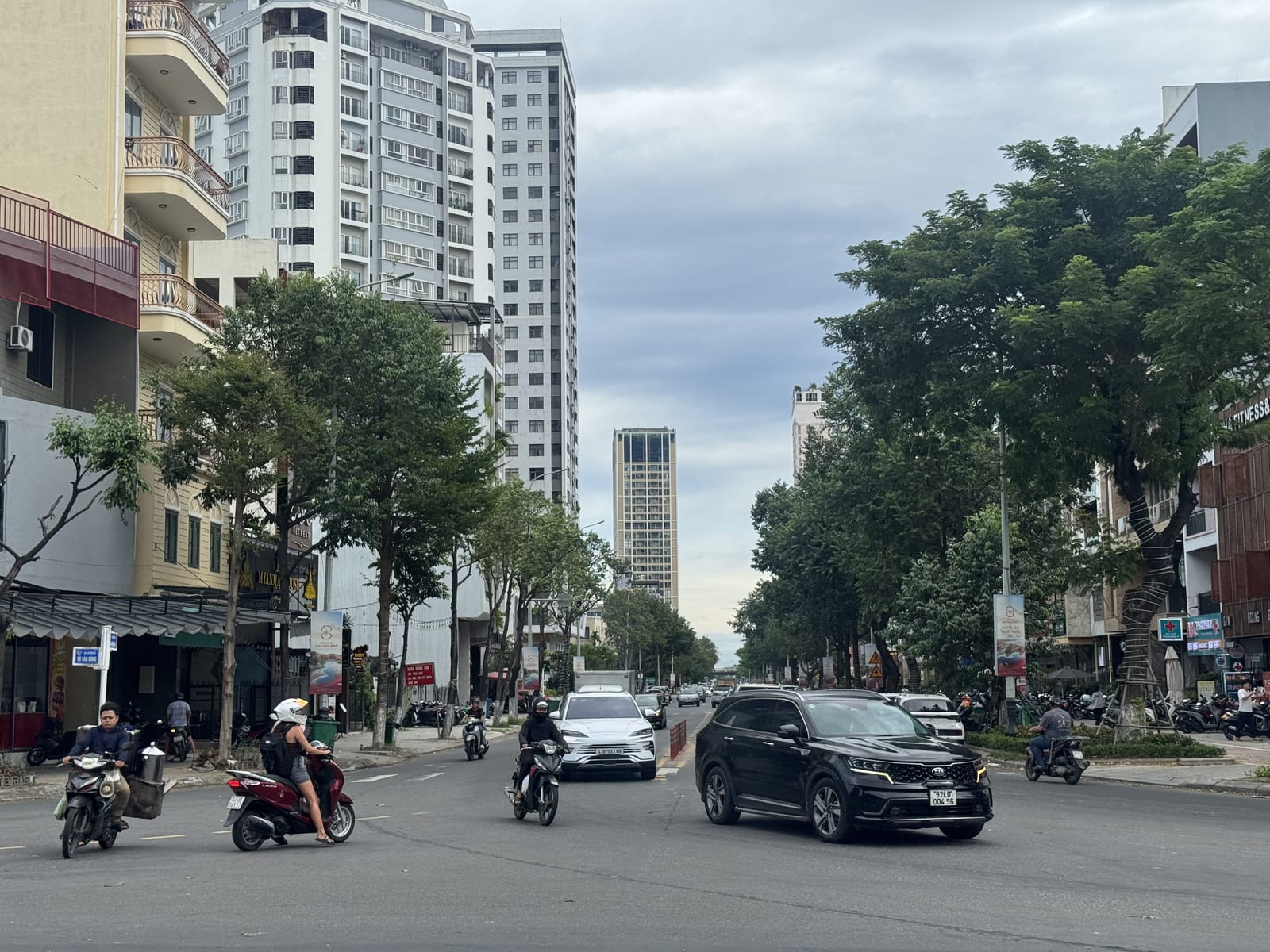 Una avenida de An Hải con motos, árboles y bloques de pisos