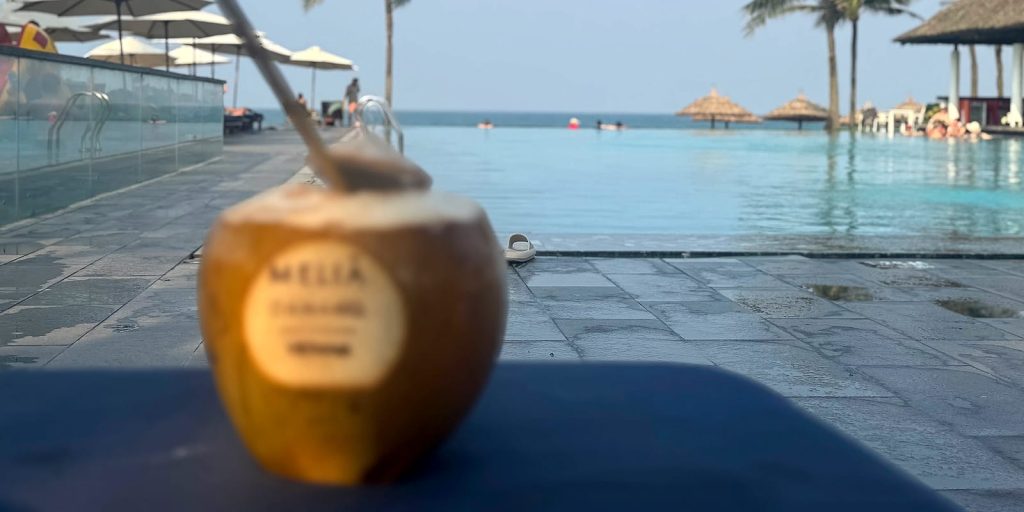 Coco con el logo del Meliá Danang delante de la infinity pool