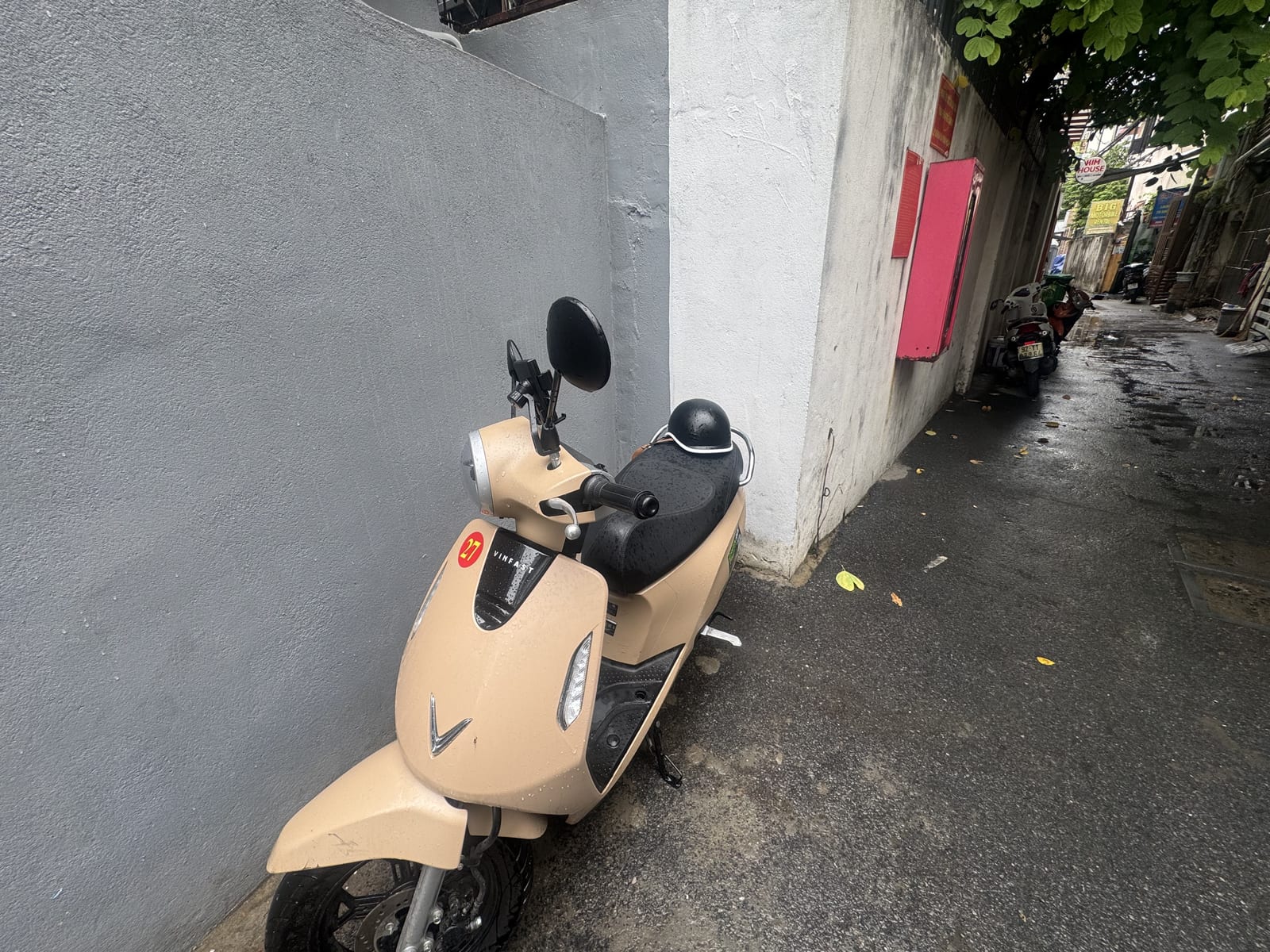 Moto eléctrica de alquiler en un callejón de Da Nang, con el casco sobre el asiento