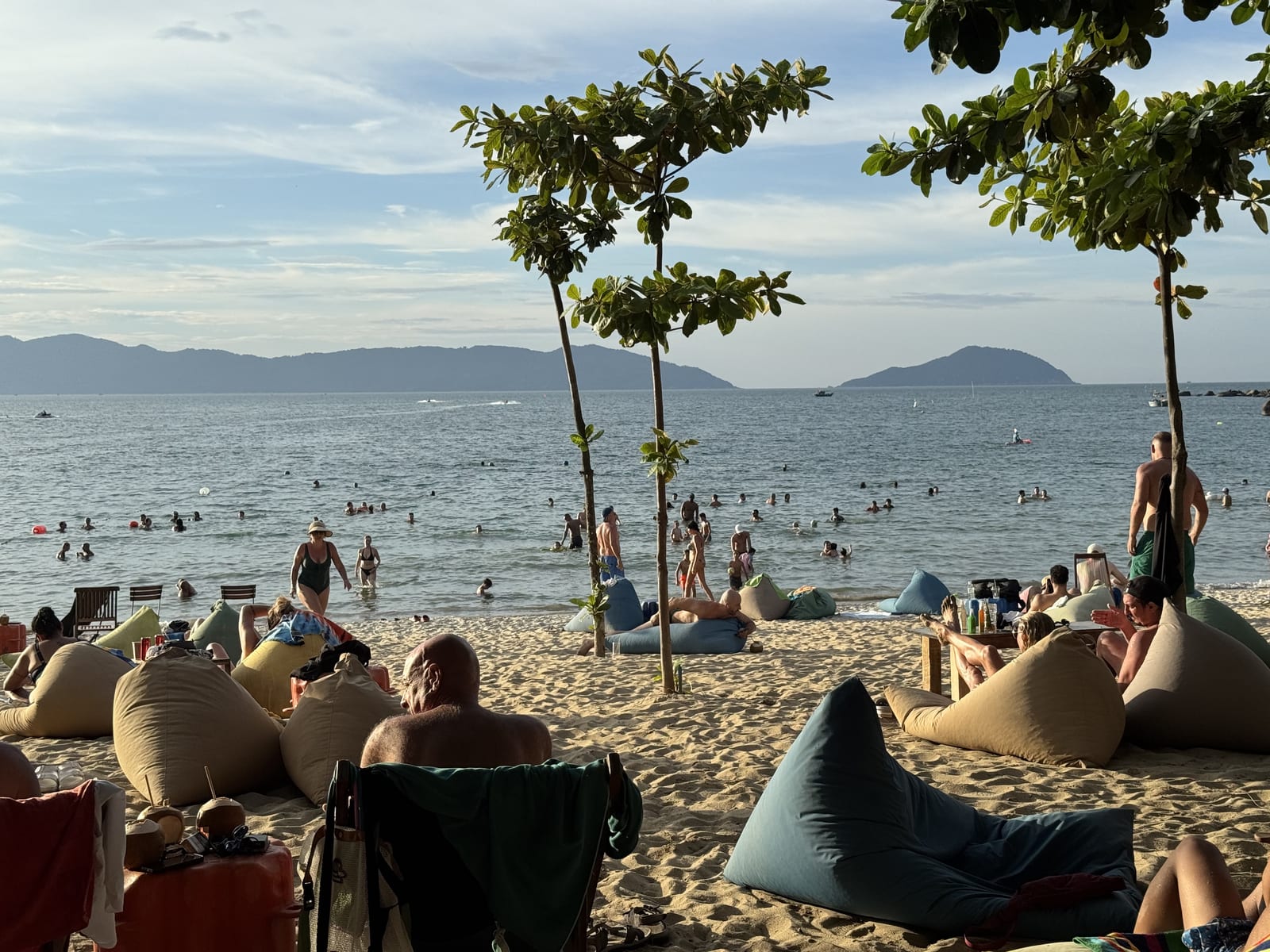 Gente en pufs y tumbonas en la playa de Da Nang a última hora de la tarde