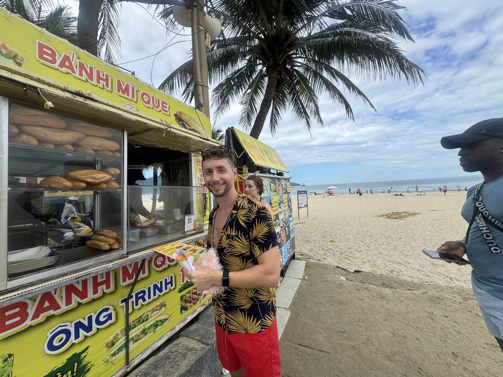 Puesto callejero de bánh mì junto a la playa de Da Nang, con la comida preparándose a la vista