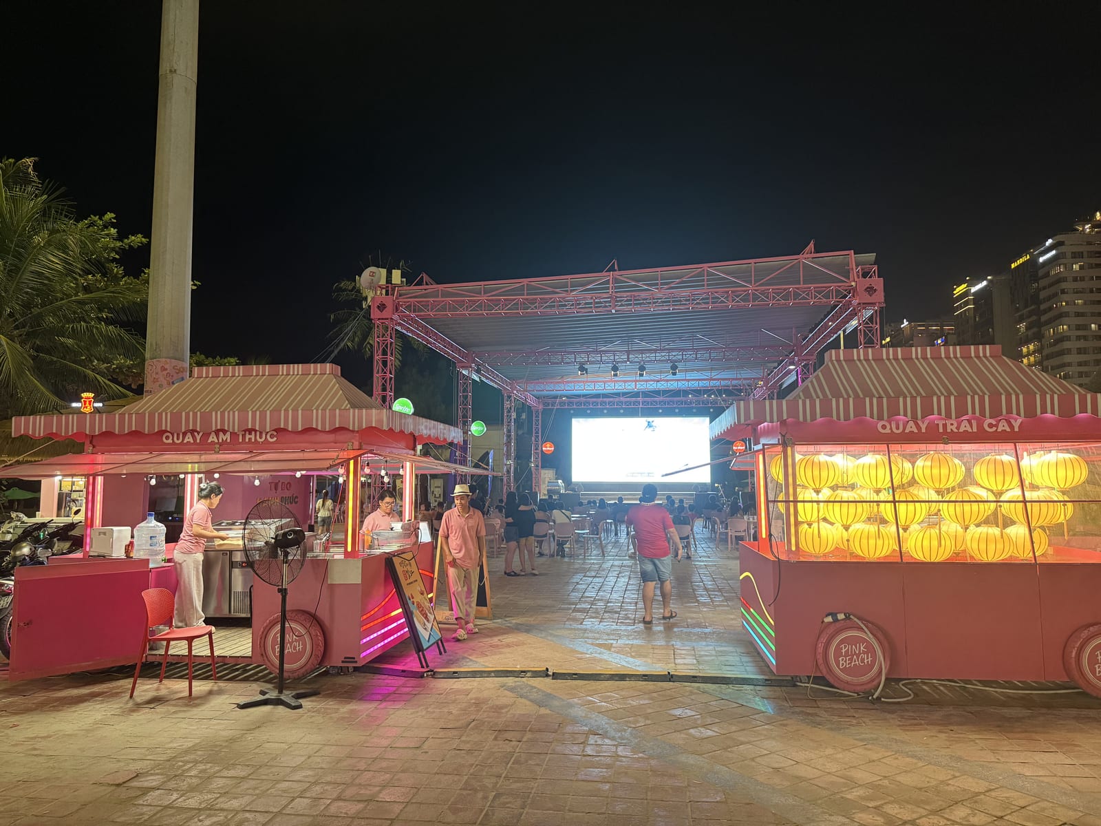 Puestos de comida iluminados en el paseo marítimo de Da Nang por la noche