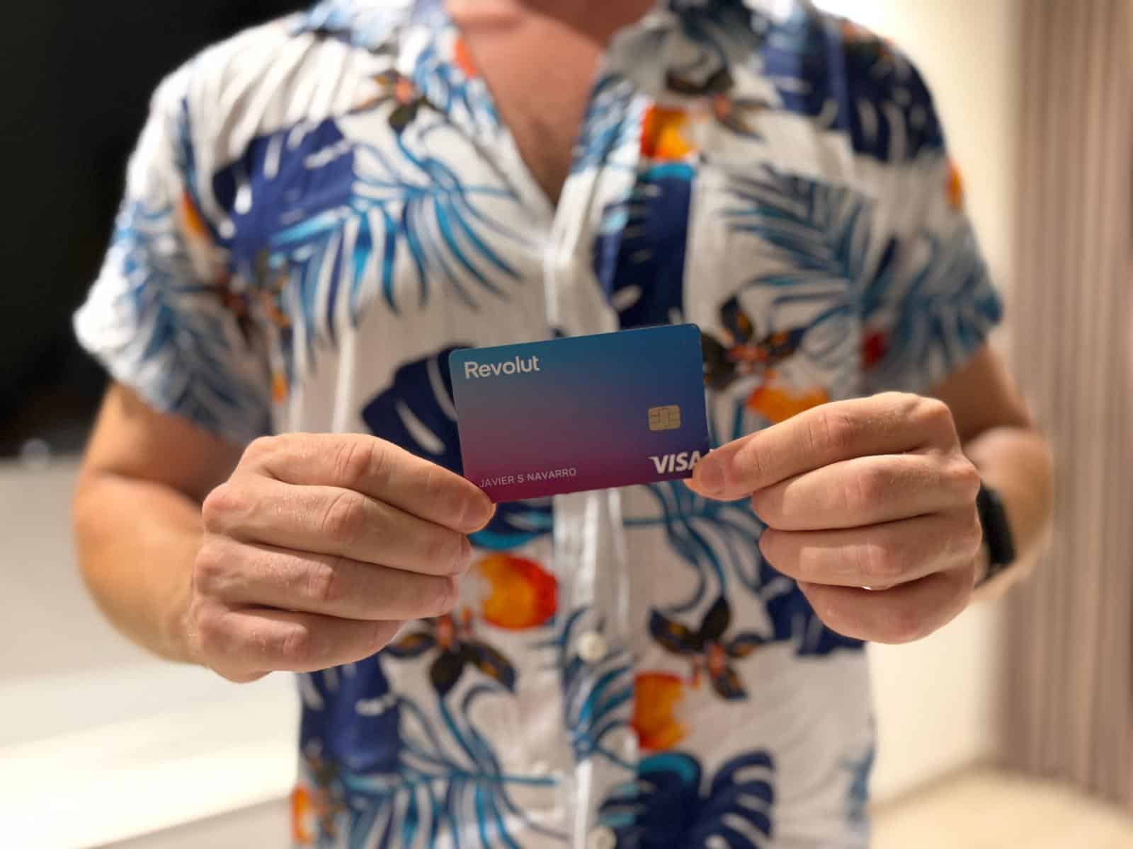 Tarjeta Visa de Revolut de color azul y morado sujetada con las dos manos