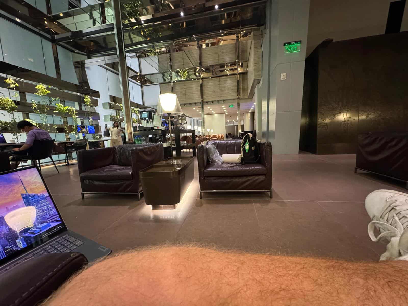 Zona de butacas de la sala VIP de Doha vista desde un asiento, con un portátil abierto en primer plano