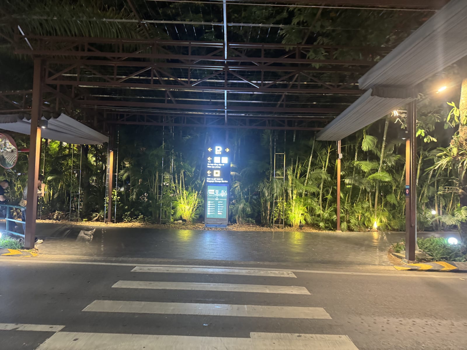 Salida de la terminal del aeropuerto de Da Nang de noche, con el paso de peatones