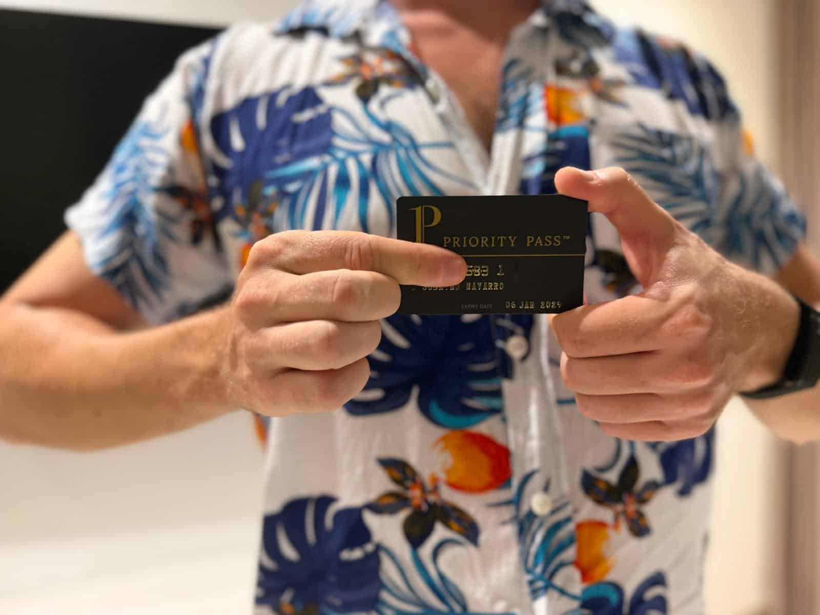 Tarjeta negra de Priority Pass sujetada con las dos manos