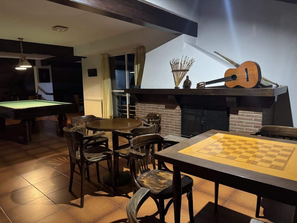 Sala de juegos del Hotel Spa Las Nubes con mesa de billar, tablero de ajedrez y guitarra