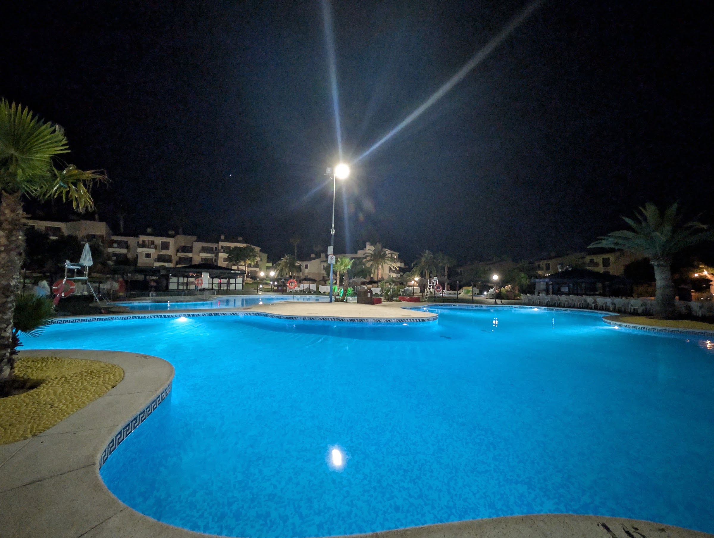 Piscina principal iluminada de noche en el Albir Garden Resort