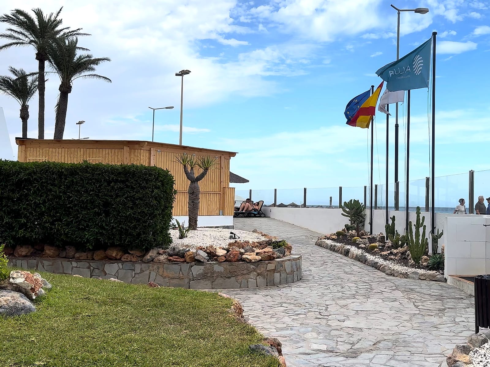 El acceso del Alua Golf Trinidad a Playa Serena, con las banderas y el paseo al fondo