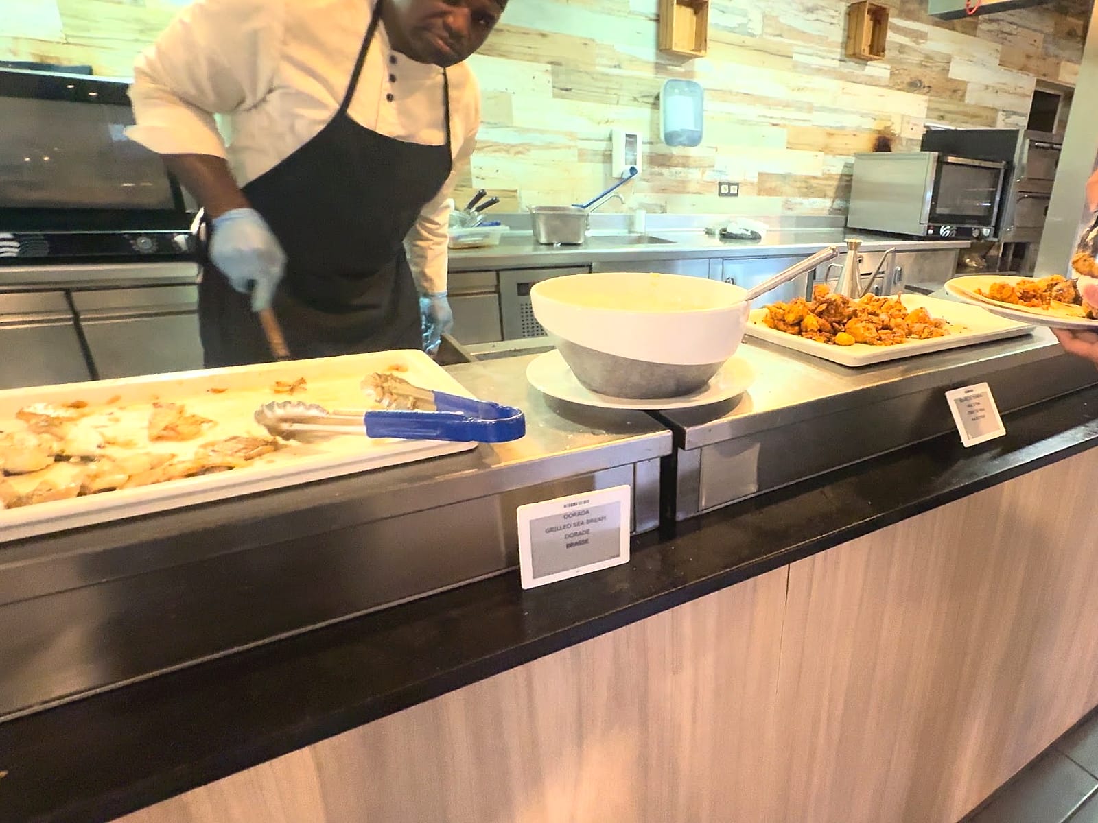 Un cocinero sirviendo en la plancha del buffet del Alua Golf Trinidad