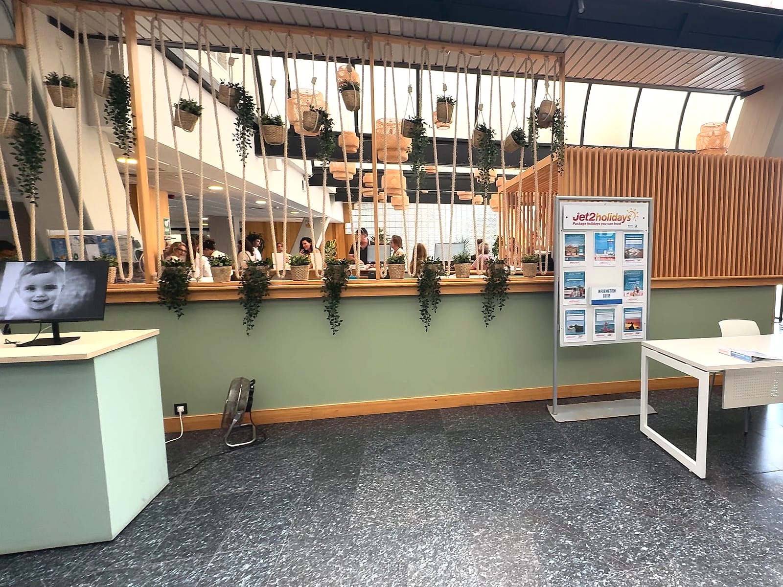 La recepción del Alua Golf Trinidad, con clientes esperando para hacer el check-in