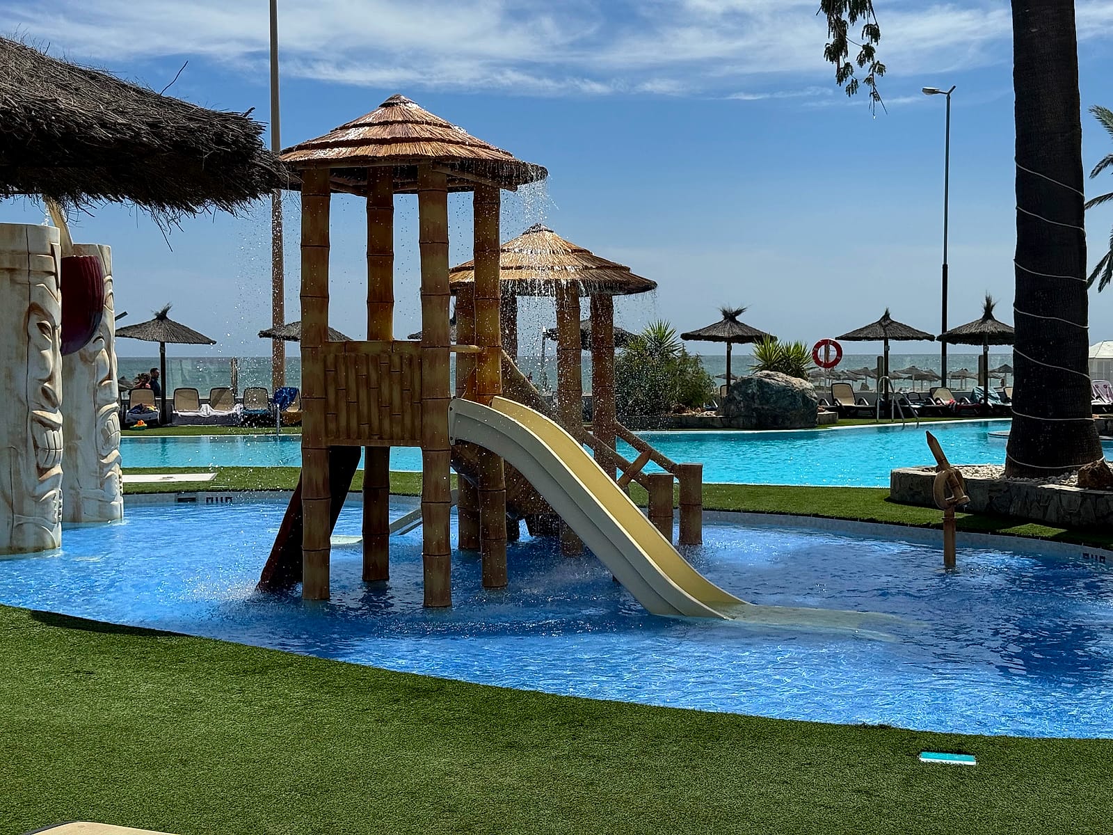 La zona de chapoteo del Alua Golf Trinidad, con una torre de madera y un tobogán pequeño