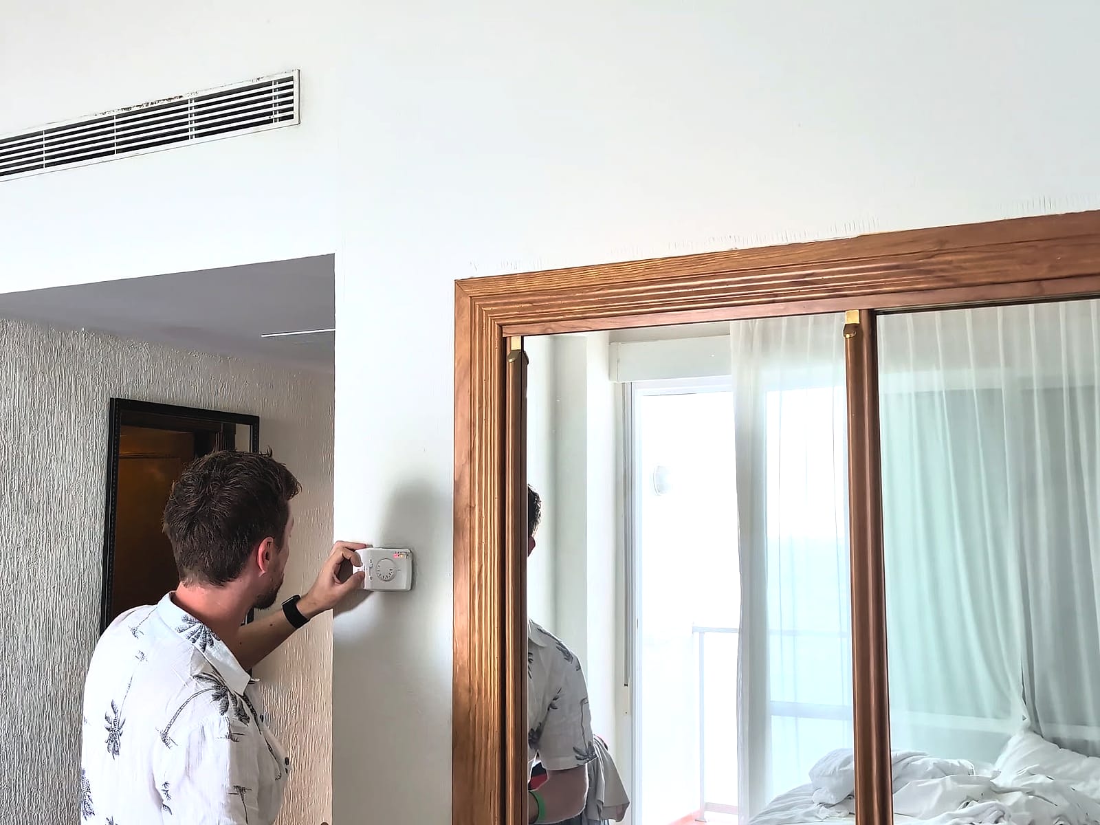 Javier Sobrino tocando el mando del aire acondicionado en la habitación del AluaSun Doblemar
