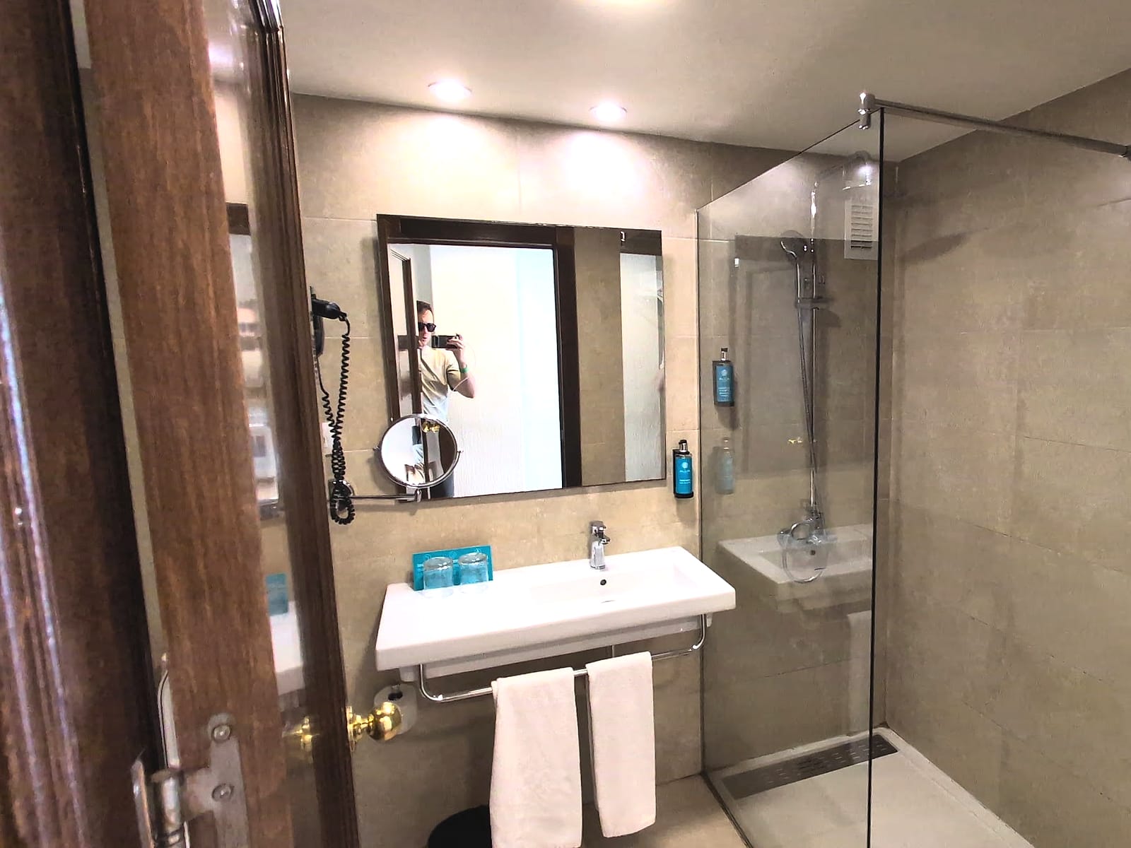 El baño renovado del AluaSun Doblemar, con ducha con mampara y lavabo blanco