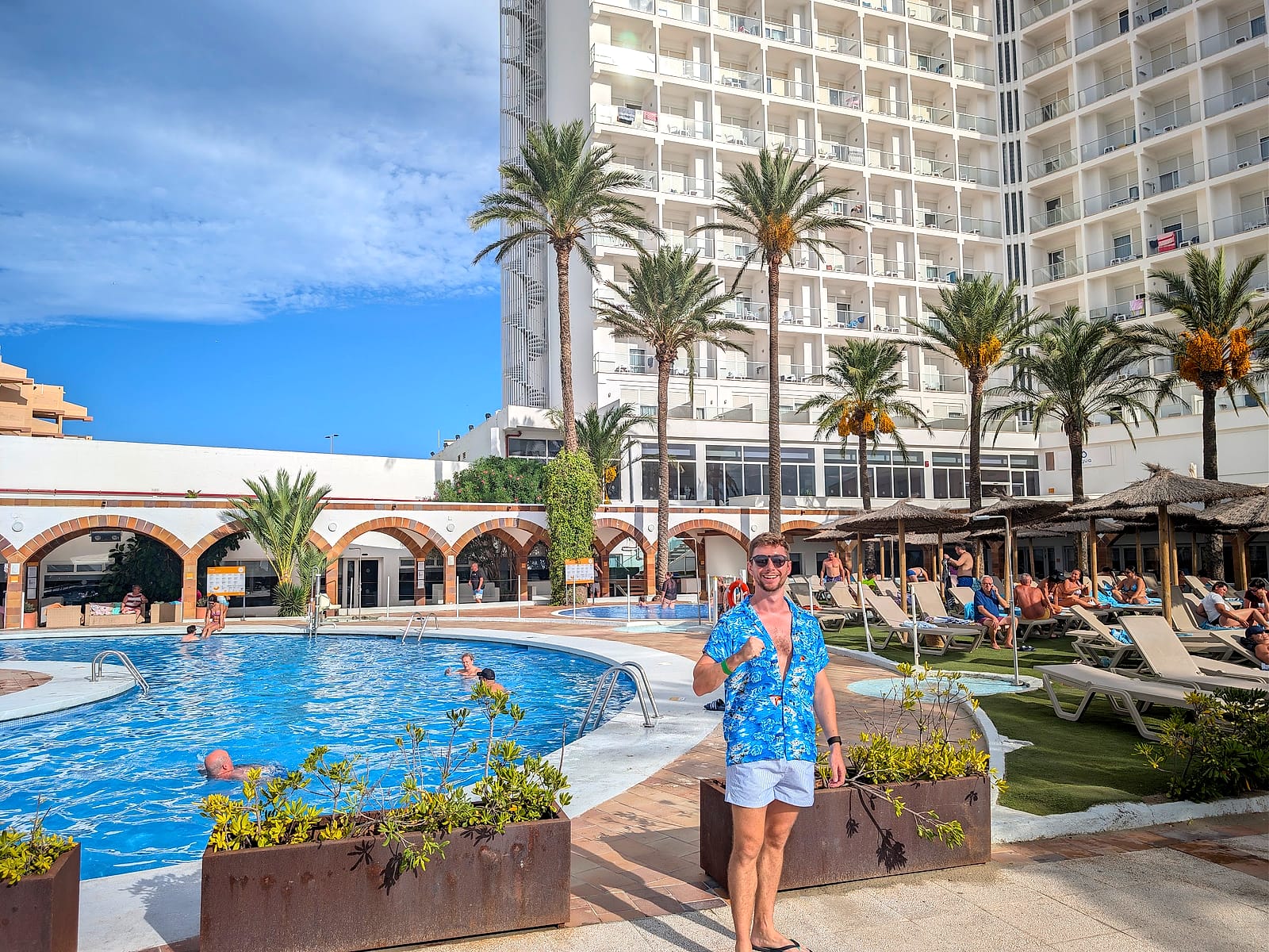 Javier Sobrino junto a la piscina principal del AluaSun Doblemar, con la torre del hotel detrás