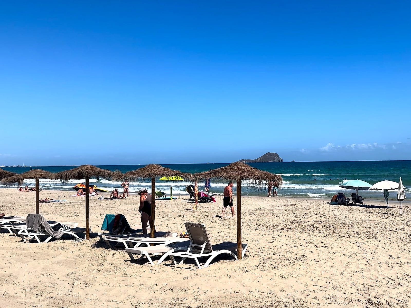 La playa del Mediterráneo en La Manga, a dos minutos del AluaSun Doblemar, con sombrillas de brezo y olas